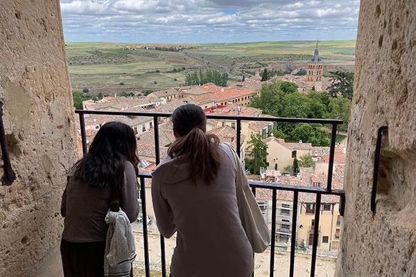 students on balcony overlooking city